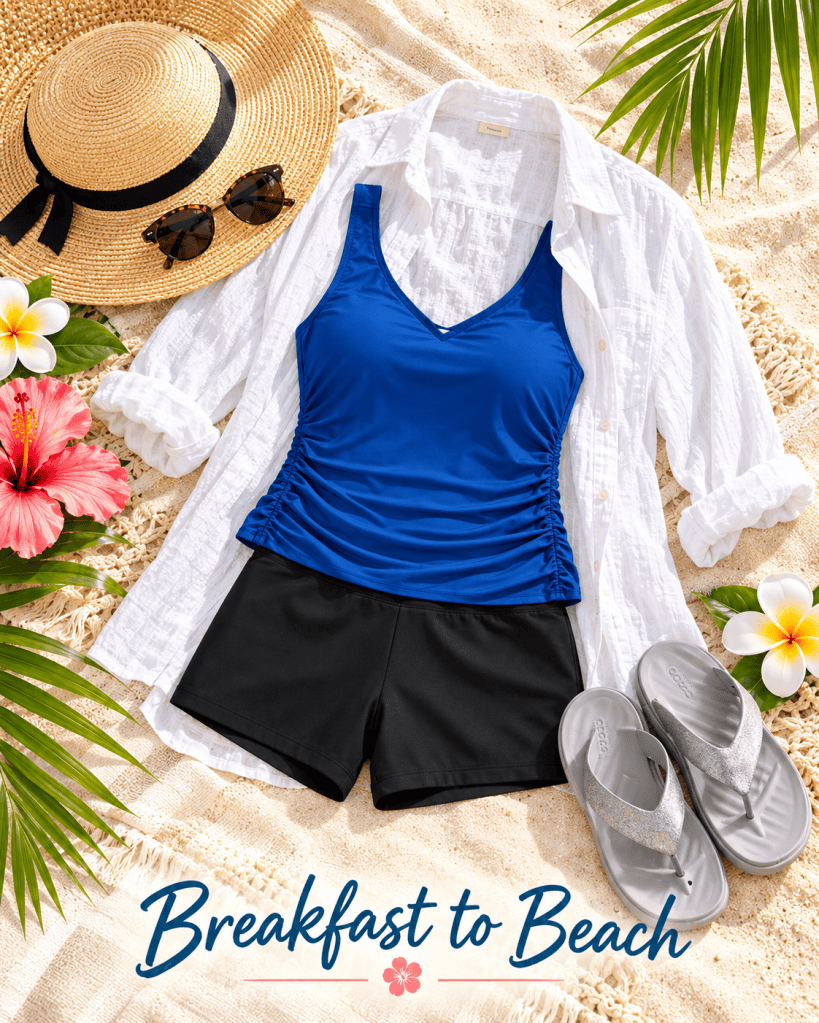A beach outfit featuring a blue tankini top, black swim shorts, a white button-up shirt, a straw hat, sunglasses, and silver flip flops, arranged on sandy beach with tropical flowers and palm leaves in the background.